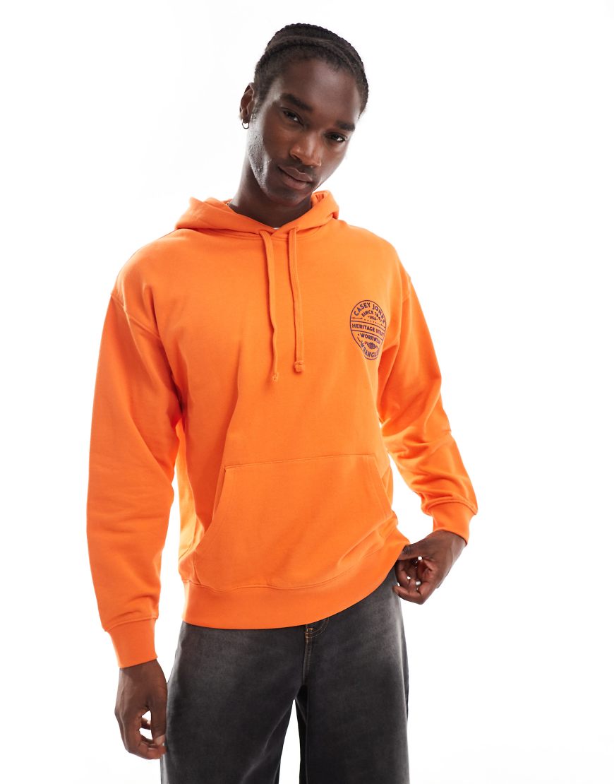 Wrangler - Casey Jones Workwear - Oversize-Kapuzenpullover in Orange mit rundem Vintage-Logo von Wrangler