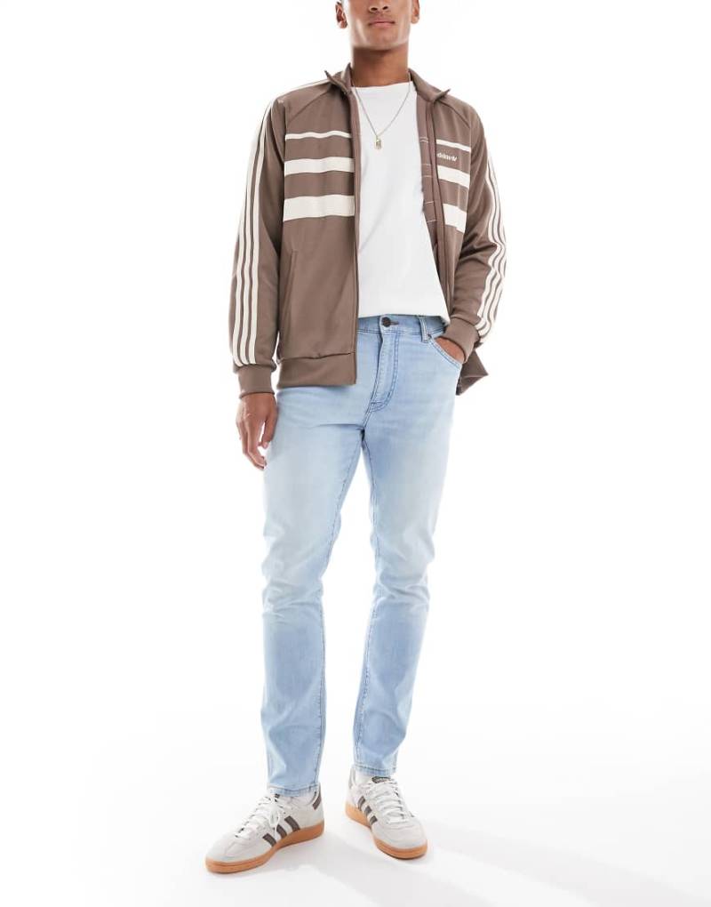 Wrangler - Larston - Schmal zulaufende Jeans mit schmalem Schnitt in mittelblauer Waschung von Wrangler