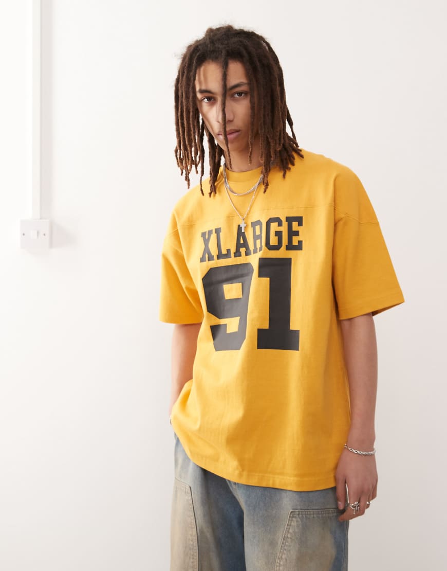XLARGE - T-Shirt in Gelb mit Oversize-Logo und „91"-Nummernprint XLARGE - T-Shirt in Gelb mit Oversize-Logo und „91"-Nummernprint von Xlarge