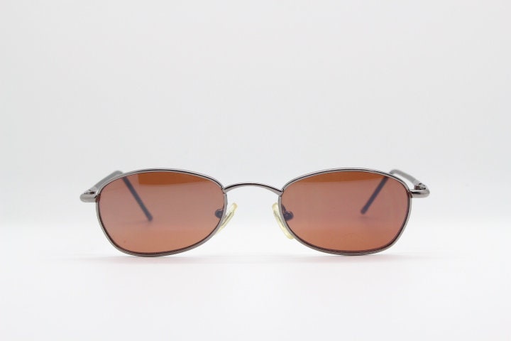 90Er Vintage Ovale Sonnenbrille. Schmales Gestell Aus Verchromtem Metall Mit Braunen Gläsern Und Schwarzen Bügeln. Zustand Unbenutzt Nos 90Er Vintage Ovale Sonnenbrille. Schmales Gestell Aus Verchromtem Metall Mit Braunen Gläsern Und Schwarzen Bügeln. Zustand Unbenutzt Nos von YouaretheBrandLondon