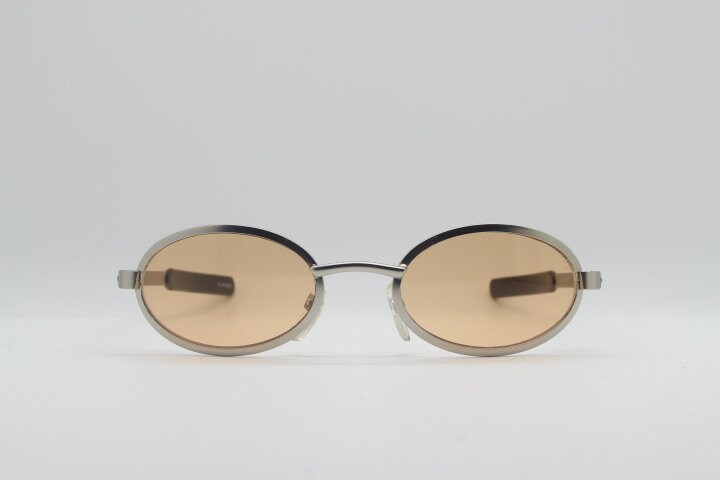 90Er Vintage Sonnenbrille in Ovaler Form. Matt Satin Silberfarbener Metallrahmen Mit Bernsteinfarbenen Gläsern Und Langen Armen. Zustand Y2K 90Er Vintage Sonnenbrille in Ovaler Form. Matt Satin Silberfarbener Metallrahmen Mit Bernsteinfarbenen Gläsern Und Langen Armen. Zustand Y2K von YouaretheBrandLondon