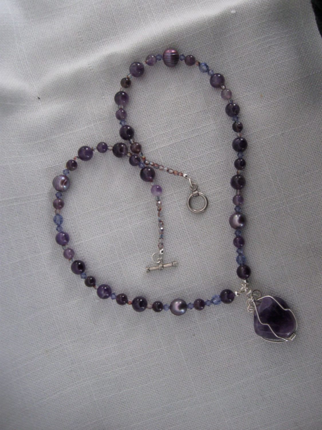 Halskette Aus Amethystperlen, Süßwasserperlen, Kristallen Und Einem Drahtumwickelten Amethyst Anhänger Halskette Aus Amethystperlen, Süßwasserperlen, Kristallen Und Einem Drahtumwickelten Amethyst Anhänger von ZydecoBeads