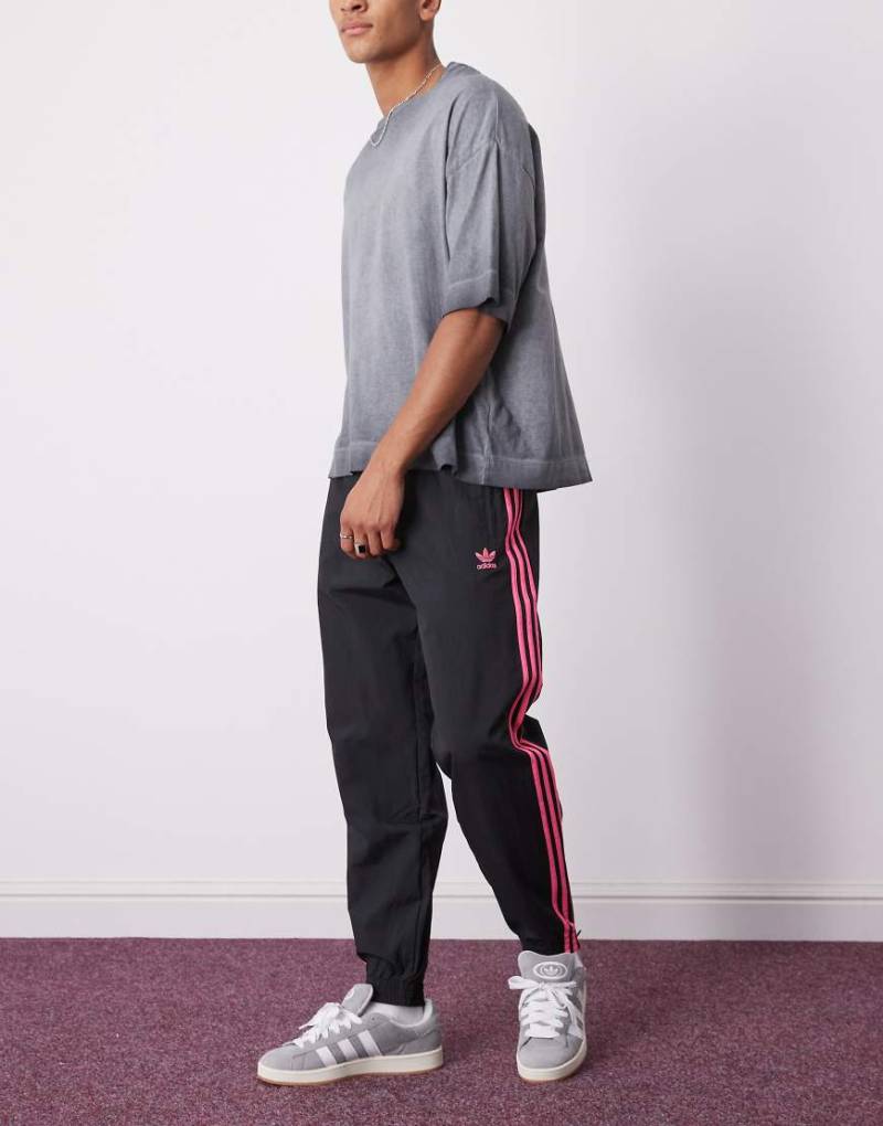 adidas Originals - Firebird - Trainingshose in Schwarz und leuchtendem Rosa von adidas Originals