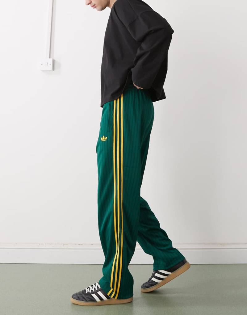 adidas Originals - Firebird Loose - Locker sitzende Trainingshose in Collegiate Grün mit Nadelstreifen von adidas Originals