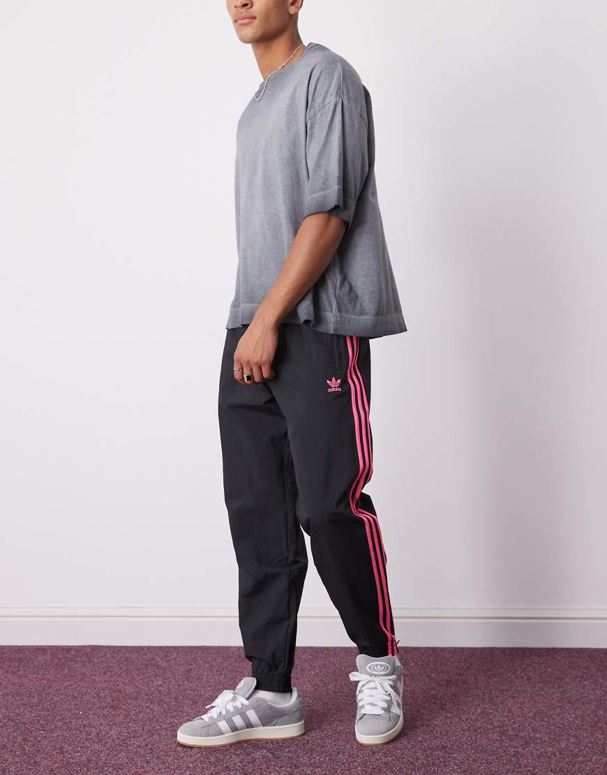 adidas Originals - Firebird - Trainingshose in Schwarz und leuchtendem Rosa von adidas Originals