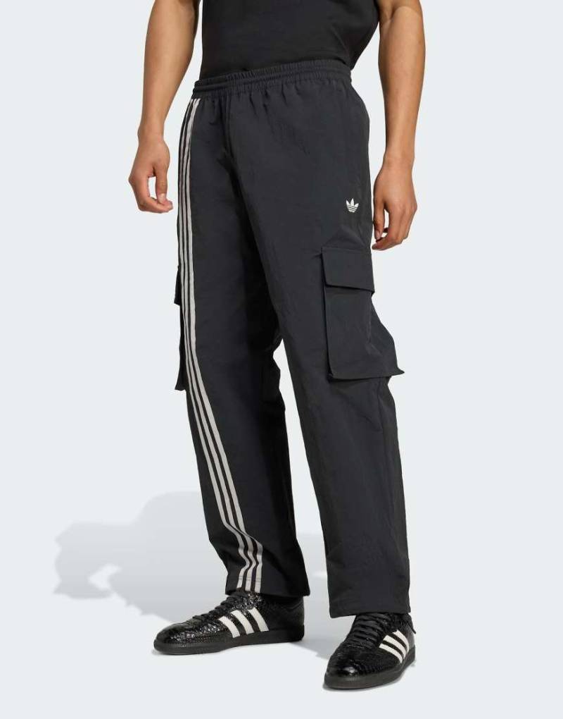 adidas Originals - Gewebte Cargohose in Schwarz mit Streifen vorne adidas Originals - Gewebte Cargohose in Schwarz mit Streifen vorne von adidas Originals
