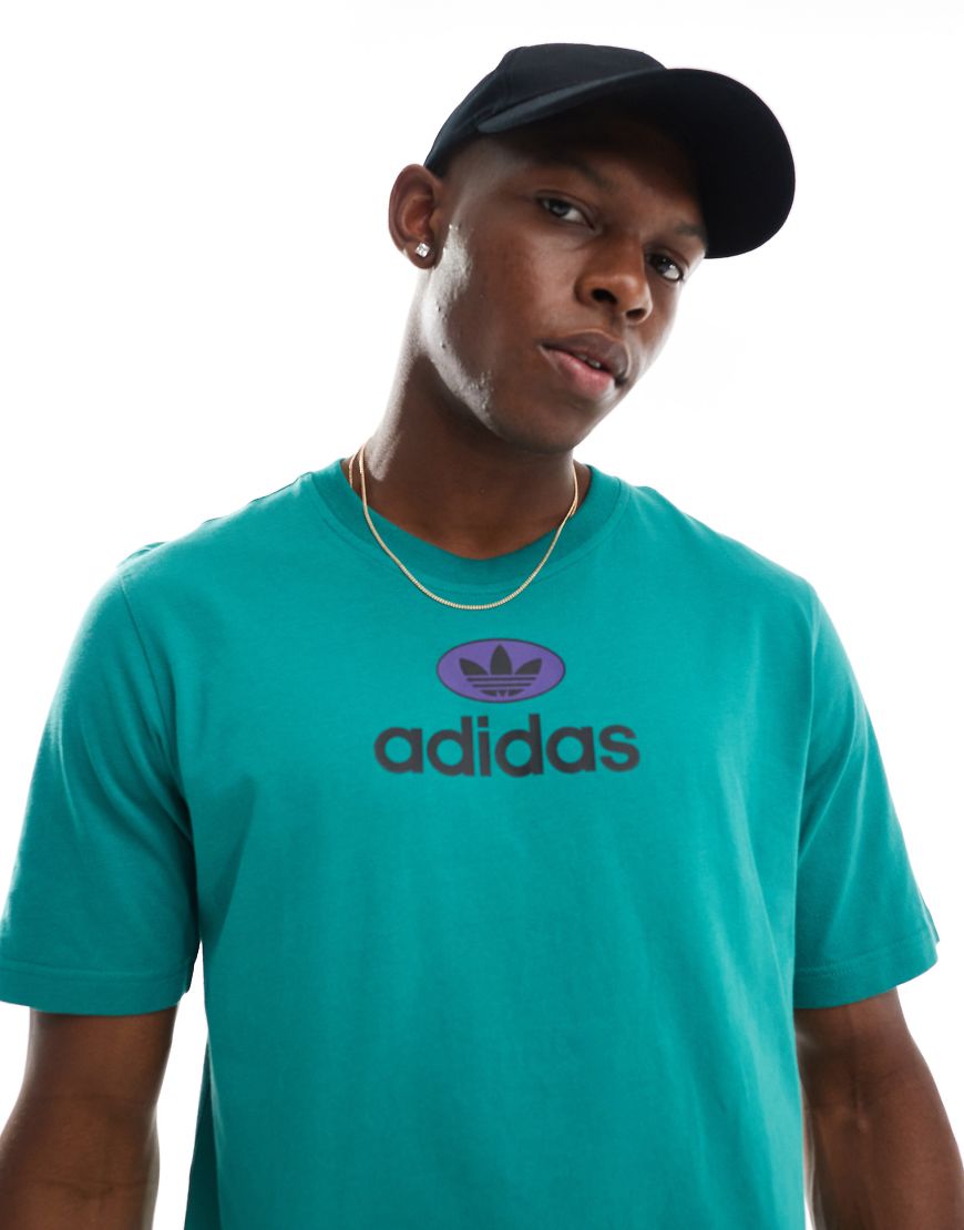 adidas Originals - T-Shirt in Grün mit Logo adidas Originals - T-Shirt in Grün mit Logo von adidas Originals