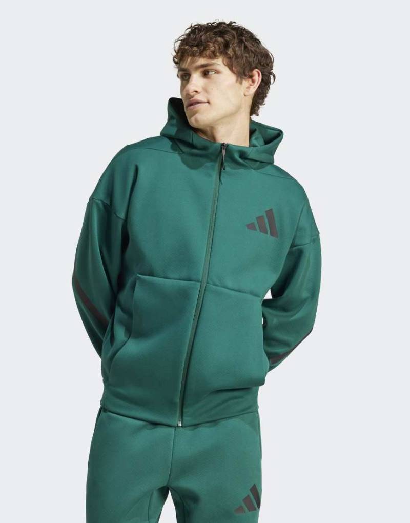 adidas Performance - Z. n.e. - Trainingsjacke in College-Grün mit Reißverschluss und Kapuze von adidas performance