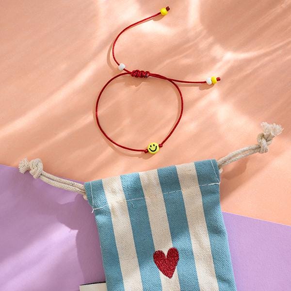Armband Smile in Dunkelrot Mit Makrameeverschluß Und Säckchen Blau/Weiss von avaundyves