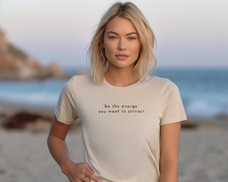 Unisex-T-Shirt "Be The Energie You Want To Attract" von carastudioshop