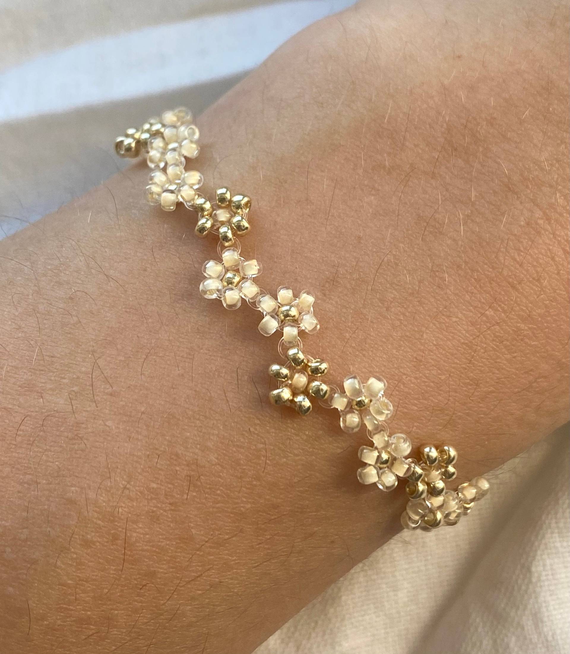 Zwei Schattierte Beige Und Goldene Zick-Zack-Blumen-Armband Zwei Schattierte Beige Und Goldene Zick-Zack-Blumen-Armband von florescerjewelry