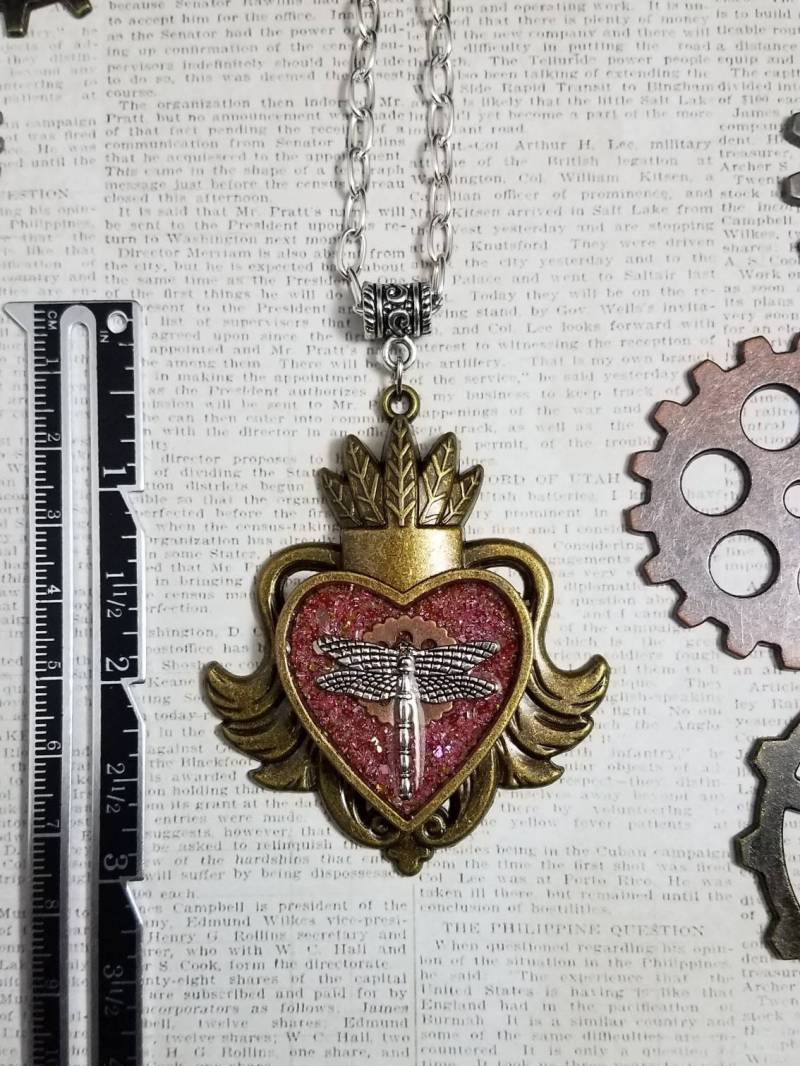 steampunk Große Geflügelte Herz Anhänger Mit Ausrüstung Und Libelle Auf Der Oberseite Rosa Glitzer Halskette steampunk Große Geflügelte Herz Anhänger Mit Ausrüstung Und Libelle Auf Der Oberseite Rosa Glitzer Halskette von gemmageluz
