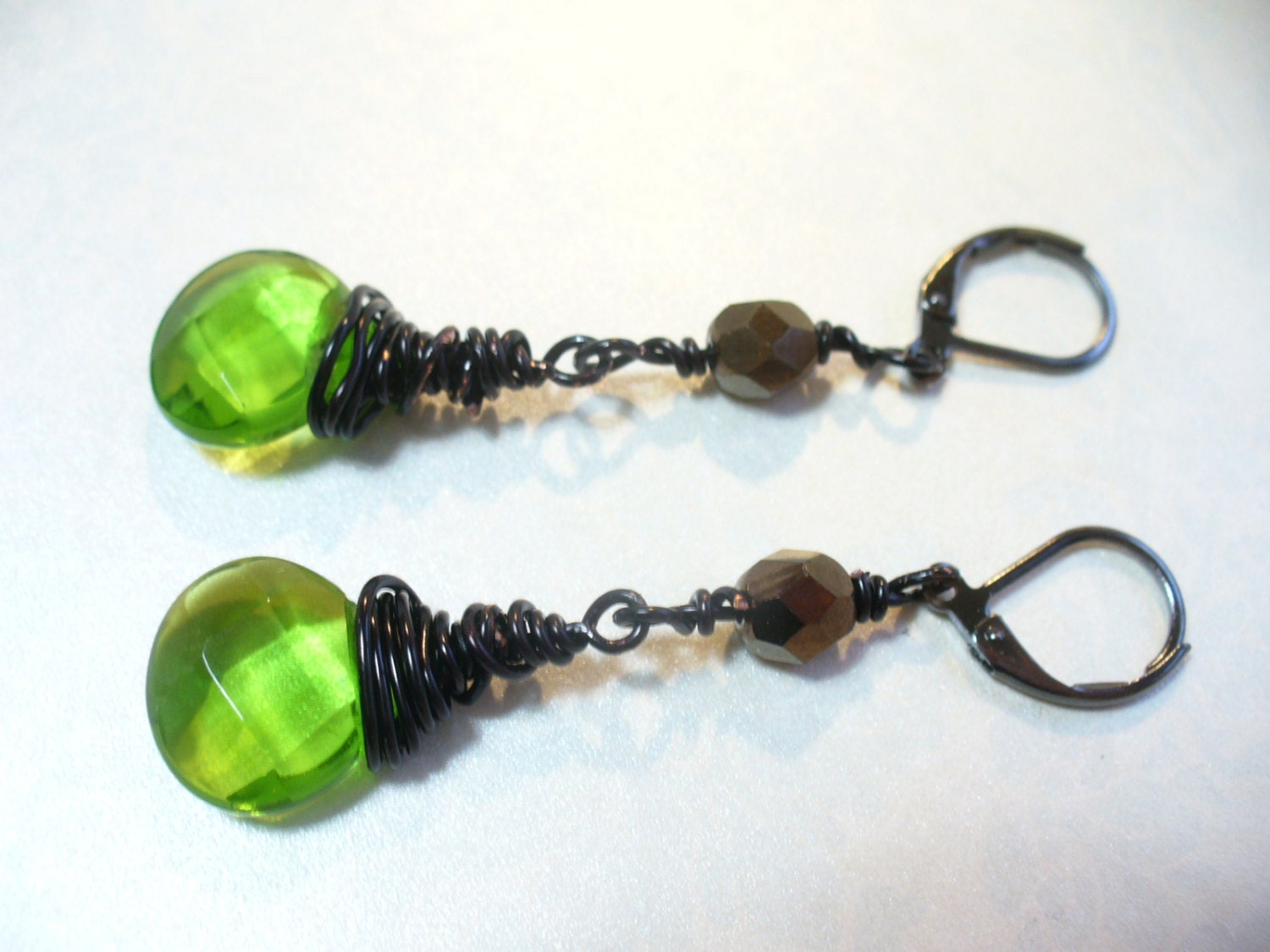 Drahtgewickelte Facettierte Grüne Glas Briolette Lange Ohrhänger Mit Schwarzen Und Messing-Verschluss Drahtgewickelte Facettierte Grüne Glas Briolette Lange Ohrhänger Mit Schwarzen Und Messing-Verschluss von karunadesigns