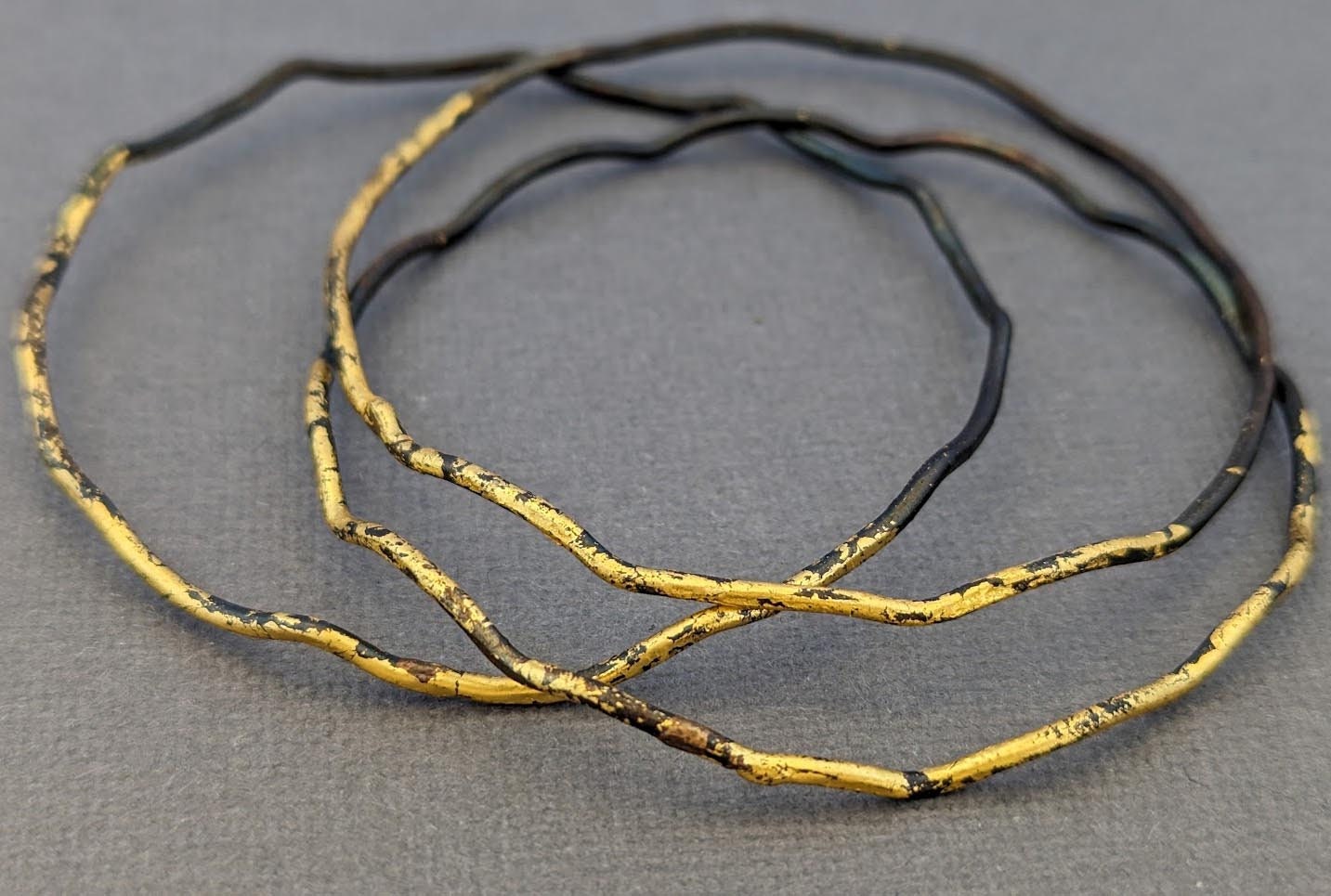 Gewellte Stahl & Gold Stapelbare Armreifen von metamorph