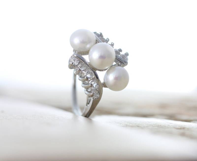 Weiß Süßwasser Perle Ring Sterling Silber Plated Größe 6-8 Mit Drei 6mm Weißen Perlen Und Fünf Zirkon Steinen Auf Jeder Seite Montiert Weiß Süßwasser Perle Ring Sterling Silber Plated Größe 6-8 Mit Drei 6mm Weißen Perlen Und Fünf Zirkon Steinen Auf Jeder Seite Montiert von orienjewel