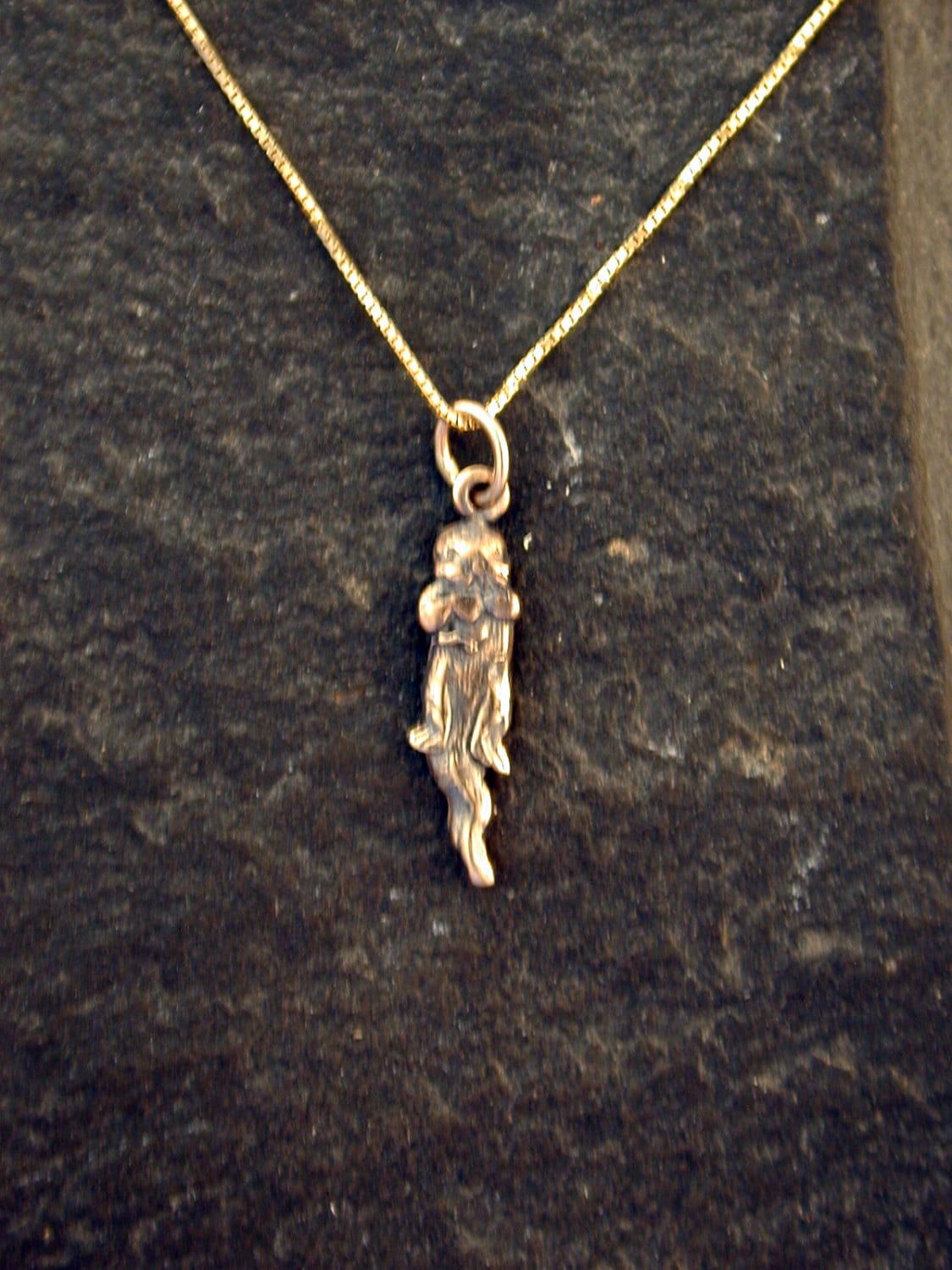 14K Gold Tiny Otter Anhänger An Einer Goldkette von peteconder