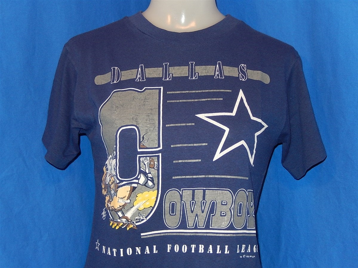 80Er Jahre Jack Dalius Cowboys Cartoon Navy Blue Vintage T-Shirt Jugend Medium 80Er Jahre Jack Dalius Cowboys Cartoon Navy Blue Vintage T-Shirt Jugend Medium von thecaptainsvintage