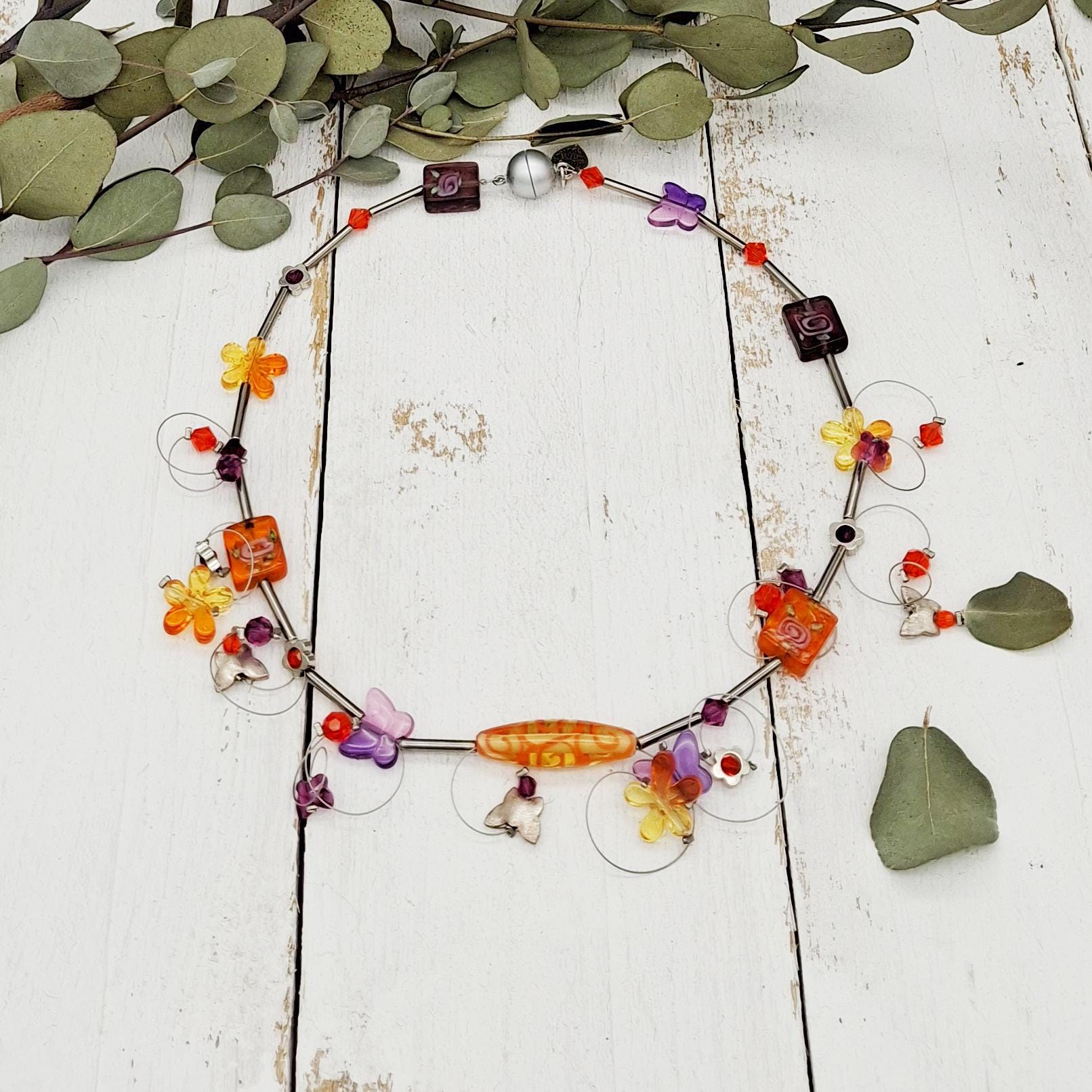 Verspielte Kette Mit Blümchen, Schmetterlingen Und Glasperlen Verspielte Kette Mit Blümchen, Schmetterlingen Und Glasperlen von tickodesign